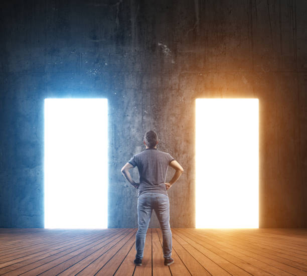 istock Young man standing looking illuminated door he will make a choice 1187262738