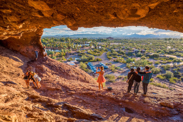 Mouth of Hole-in-the-Rock People snap pictures of themselves in the mouth of Hole-in-the-Rock, a tourist attraction in Papago Park, Arizona. It was once used by the ancient Hohokam people to mark the turn of the seasons. phoenix stone stock pictures, royalty-free photos & images