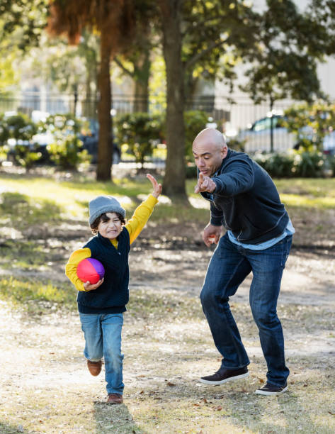istock Hispanic boy and father playing with football 1187263650
