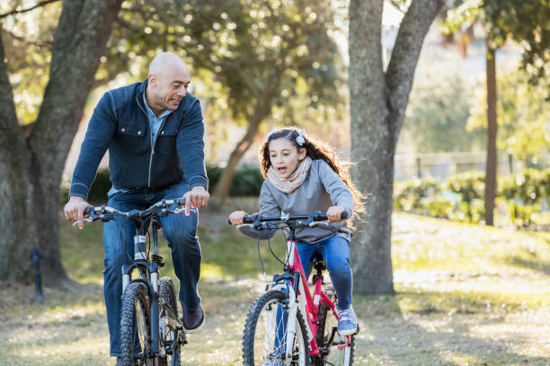 istock Hispanic father and daughter riding bicycles 1187263651