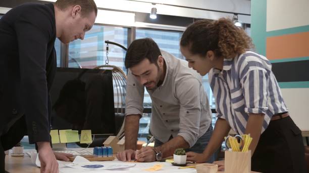 istock Creative business people group having conversation at office desk in workplace. 1187267050