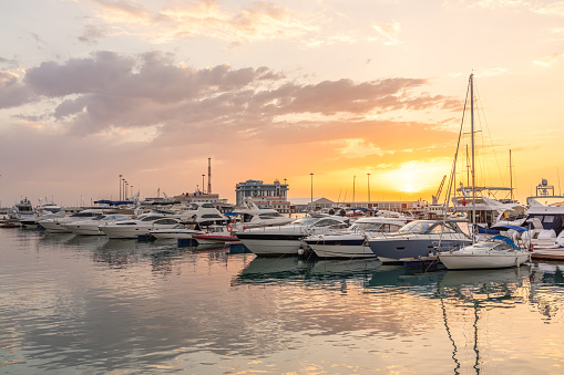 Beautiful sunset in the sea harbor with moored yachts. Sochi, Russia.