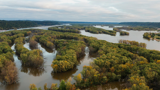 Aerial view of Upper Mississippi river (bottomland forests, open water, wetlands, islands) at Wisconsin Minnesota border. Autumn fall season (october). Landscape from above, drone shot. Sunrise, sunny