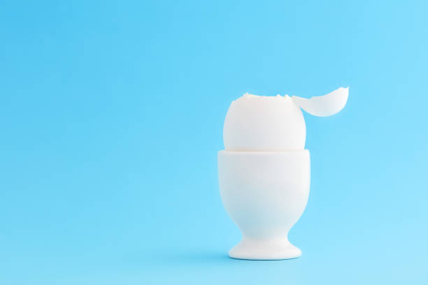istock One white egg in egg cup with with an open top ready for eating on blue background 1187288048