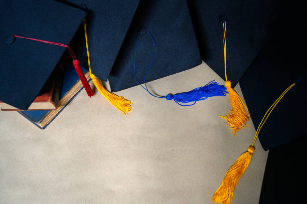 istock Black graduates' hats put on brown paper. 1187288760