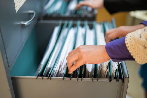 istock Employees use their hands to search documents in file cabinets. 1187288959