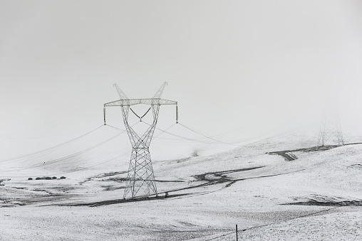 electricity pylon on mountain which covered with snow