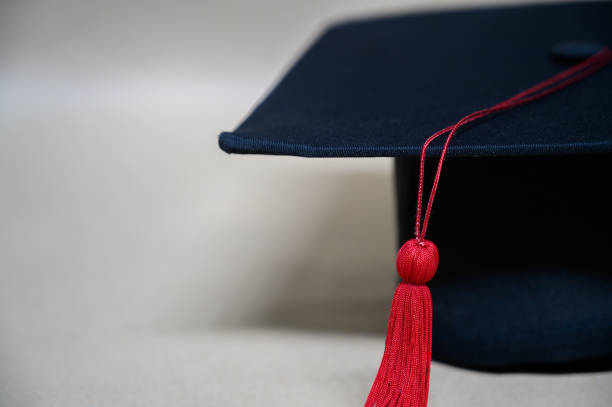 istock close up Black graduation cap And red tassels 1187290397