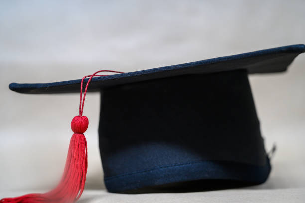istock close up Black graduation cap And red tassels 1187291522