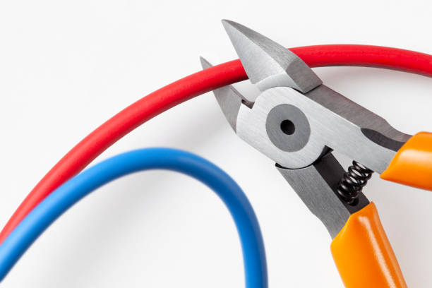 Metal nippers is cutting red wire and leaving blue on white background.