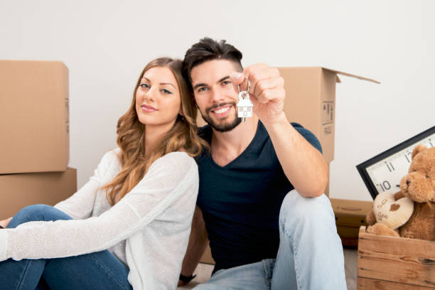 istock Young couple holding their new house keys 1187295625