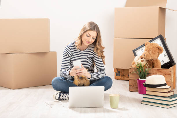 istock Young woman with boxes just moving into her new home 1187295721