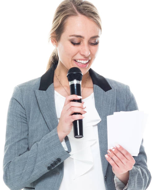 una persona / vista frontal / cintura para arriba de 20-29 años adulto hermosa mujer caucásica / mujer de negocios joven / persona de negocios / orador público de pie con un traje que está sonriendo / feliz / alegre / dando voz / hablando / presentando - sound 20s 20 25 years adult fotografías e imágenes de stock