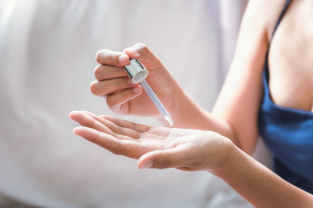 beauty body skin care and cosmetic apply concept, close-up of woman hands is applying moisturizing serum for healthy skin. beautiful woman is using moisturizer aging serum treatment on her hands. - moisturizer cosmetics merchandise human hand imagens e fotografias de stock