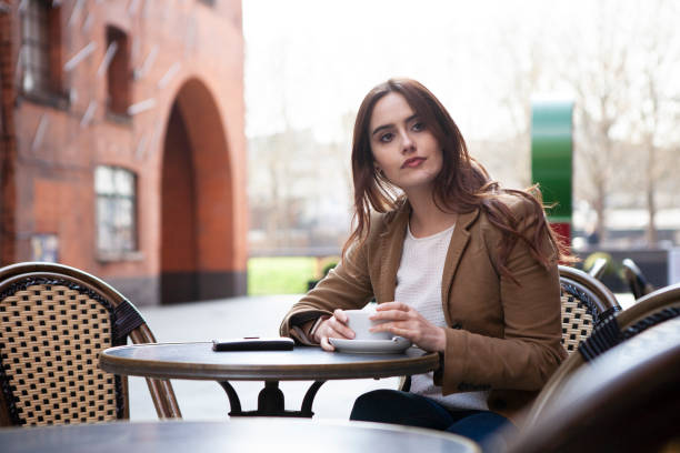 istock Woman with coffee outside cafe 1187304734