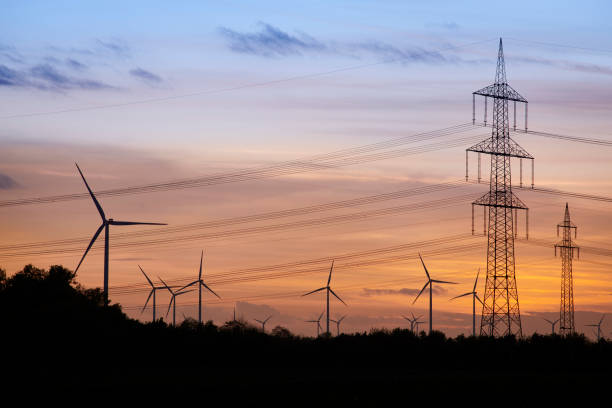 istock Wind turbines and high voltage pylons in the evening sun 1187307039