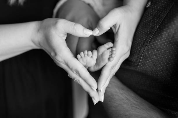 心を持つママの手に新生児の足 - human foot baby black and white newborn ストックフォトと画像