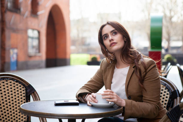 istock Woman with coffee outside cafe 1187309340