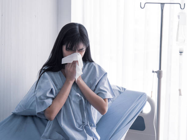 istock young woman is sneezing. 1187310473