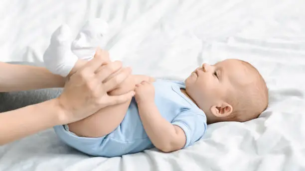 Photo of Mom doing gymnastics with her newborn child to relieve constipation.