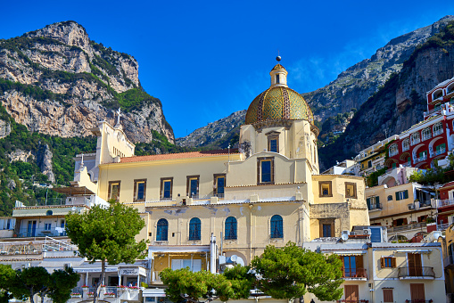 Looking at the famous Santa Maria Assunta church at the village of Positano on the Amalfi coast. Many of the small villages along the Amalfi coastline are hundreds of meters above sea level, because of the geographical reasons. The Amalfi coast is a stretch of coastline on the northern coast of the Salerno Gulf on the Tyrrhenian Sea, located in the Province of Salerno of southern Italy. The Amalfi Coast is a popular tourist destination for the region and Italy as a whole, attracting thousands of tourists annually. In 1997, the Amalfi Coast was listed as a UNESCO World Heritage Site.
