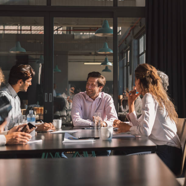 istock Smiling businesspeople having a meeting around a boardroom table 1187315430
