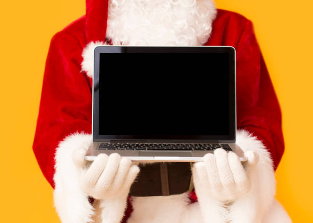 istock Santa Claus holding open laptop with black blank screen 1187315634