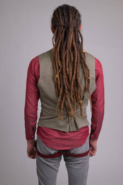 Rear view of young businessman with dreadlocks Studio shot of young handsome businessman with dreadlocks against white background body adornment rear view young men men stock pictures, royalty-free photos & images