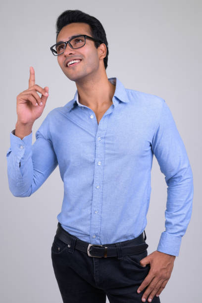 istock Happy young handsome Indian businessman thinking while pointing up 1187317818