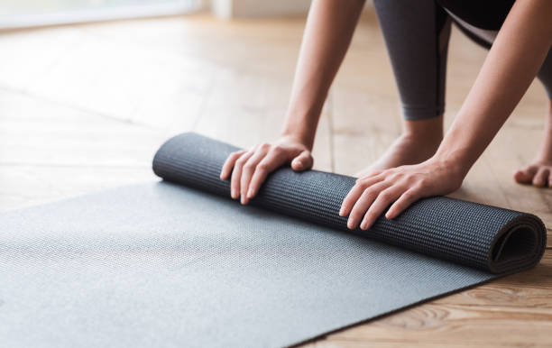 istock Hands of woman unrolling yoga mat before practice 1187320308