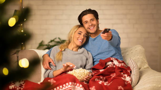 istock Cozy winter evening. Loving couple watching tv 1187320861