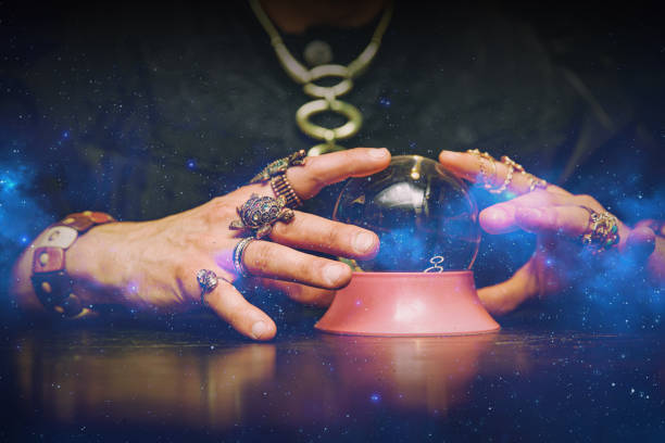 el hechicero usa una bola de cristal para predecir el futuro. - fortune teller fotografías e imágenes de stock