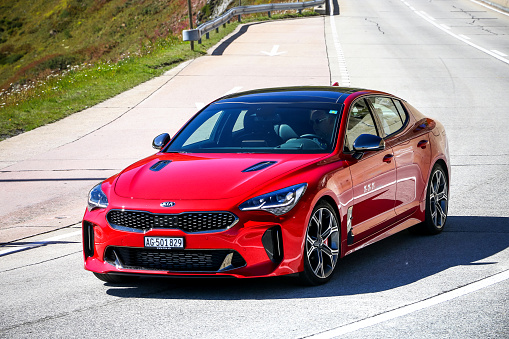 Saint Gotthard Pass, Switzerland - September 13, 2019: Red saloon car Kia Stinger at the interurban road.