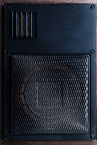 Black powerful speaker standing on the floor against vintage brick wall.Concept of recording or music studio Bookshelf speaker standing on the dark shelf against brick wall.Empty space for text home recording studio setup stock pictures, royalty-free photos & images