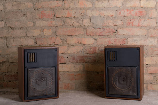 Retro audio sound system against old brick background.Empty space for design Bookshelf speaker standing on the dark shelf against brick wall.Empty space for text home recording studio setup stock pictures, royalty-free photos & images