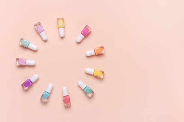 istock Nail polish bottles laid on a pink background. Top view, copy space. 1187331027