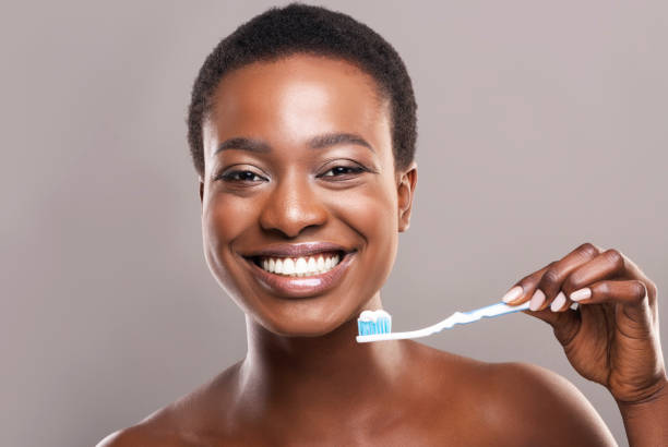 happy african american girl holding toothbrush with applied toothpaste - hairstyle crest imagens e fotografias de stock