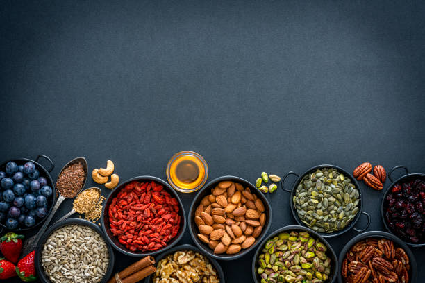 fondos alimenticios saludables: surtido de frutos secos, semillas y marcos de frutas. vista superior. - sesame seed spoon variation fotografías e imágenes de stock