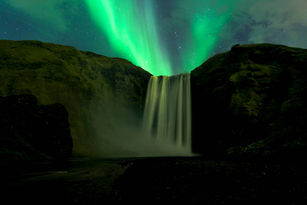 Northern Lights in the night sky over the Skogafoss waterfall in Iceland Northern Lights, polar light or Aurora Borealis in the night sky over the Skogafoss waterfall in Iceland. Clear beam raising up from behind the waterfall. skogafoss stock pictures, royalty-free photos & images
