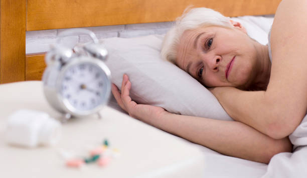 istock Upset senior ledy with sleep disorder lying in bed 1187341550