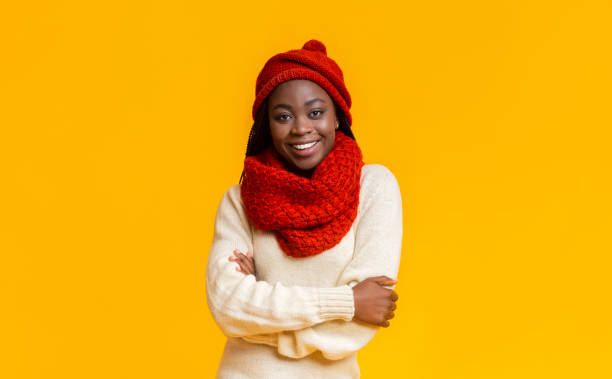 istock Confident winter black girl smiling over yellow studio background 1187341765