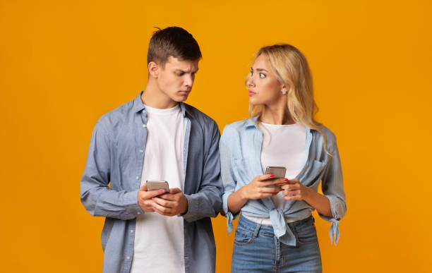istock Jealous boyfriend looking at girlfriend's cellphone, checking her messages 1187341798