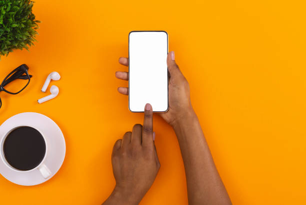 Black female using smartphone for listening music online in erphones Top view of woman's hands using touching blank screen on smartphone, downloading app for listening music online in erphones, copy space black orange audio stock pictures, royalty-free photos & images