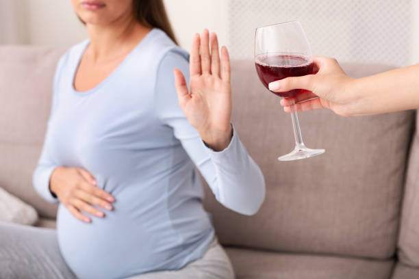 irriconoscibile donna incinta gestring stop a bicchiere di vino al chiuso - abdomen addiction adult alcohol foto e immagini stock