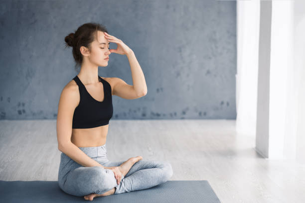 istock Young woman practicing yoga, Alternate Nostril Breathing technique 1187344261