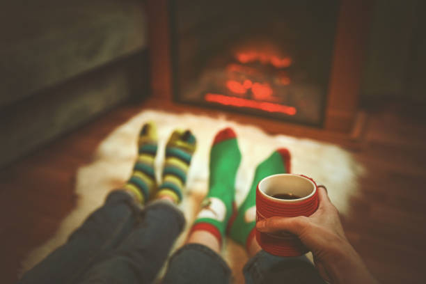 istock Feet in wool socks near fireplace in winter time 1187344907