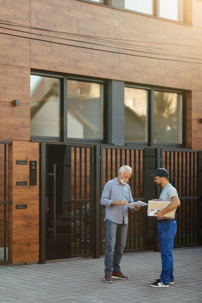 istock Senior man signing for a home delivery from a courier. 1187345480