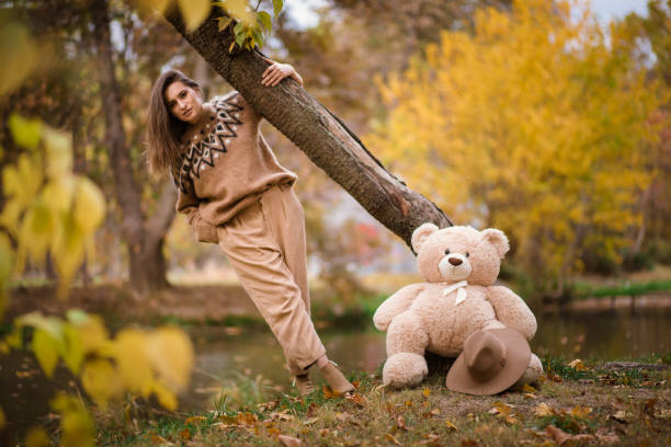 istock Girl with teddy bear in a beautiful natural park. 1187346743
