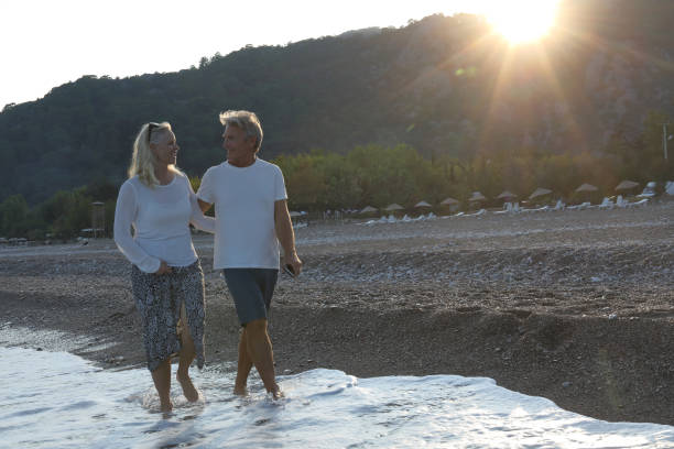 istock Couple walks down beach at sunrise 1187347980