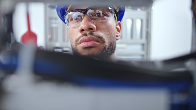 DS Face of a male electrician looking into the electrical panel and connecting wires